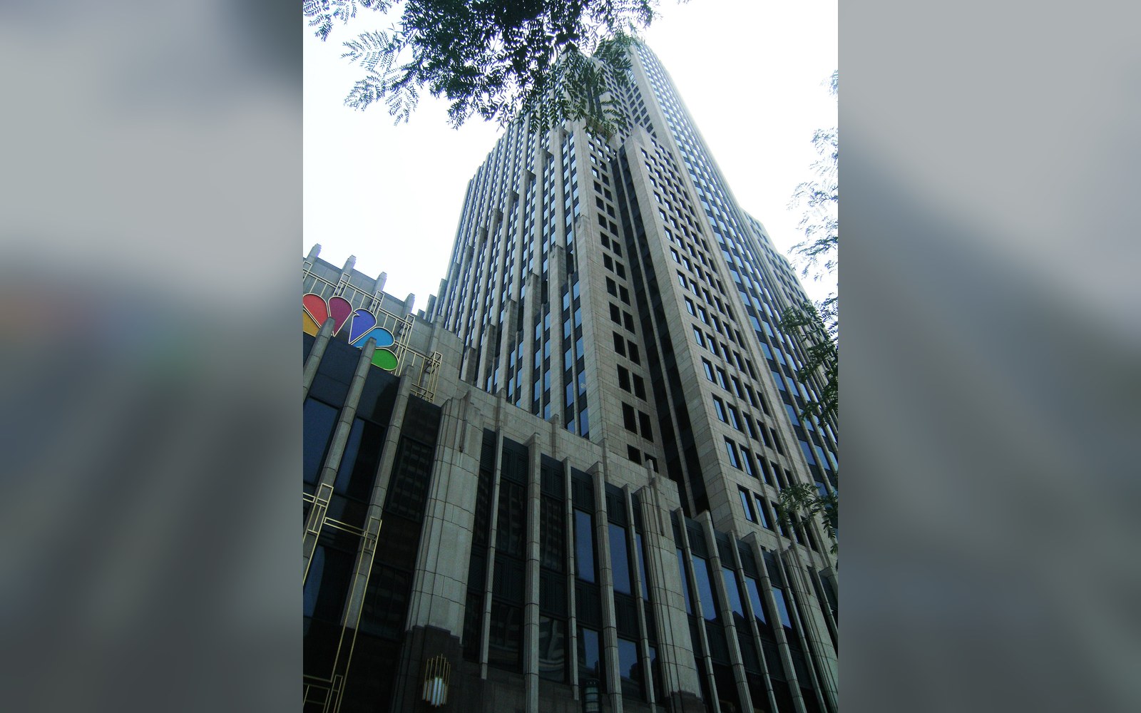 Low-angle view of a skyscraper with the NBC peacock logo near its base